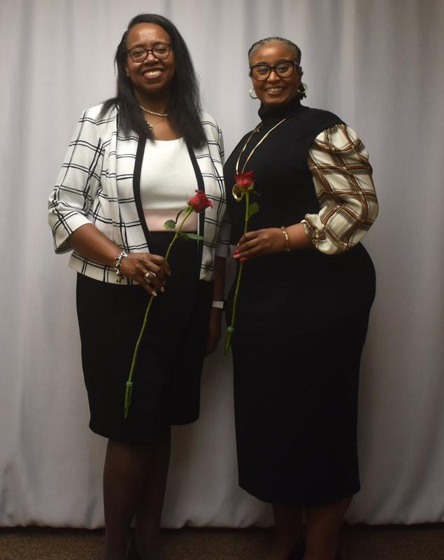 Two branch leaders holding roses at a recognition ceremony